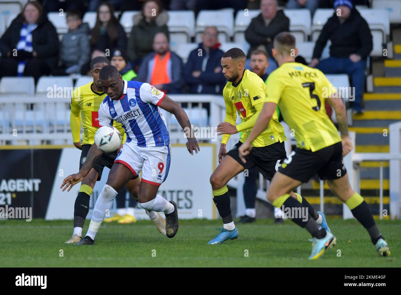Hartlepool, UK. 19th Nov, 2022. Hartlepool United's Josh Umerah looks to beat two Harroagte Town Defenders during the FA Cup Second Round match between Hartlepool United and Harrogate Town at Victoria Park, Hartlepool on Saturday 26th November 2022. (Credit: Scott Llewellyn | MI News) Credit: MI News & Sport /Alamy Live News Stock Photo