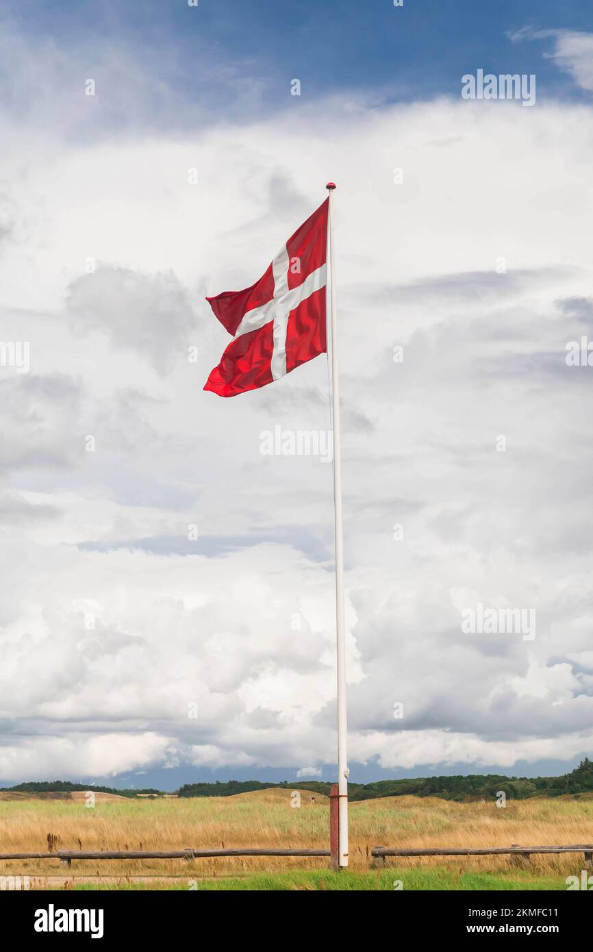 Danish flag on a flagpole against a beautiful cloudy sky Stock Photo