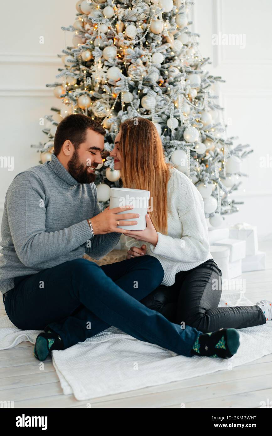 Cute, young couple exchanging Christmas gifts for Christmas morning Stock Photo