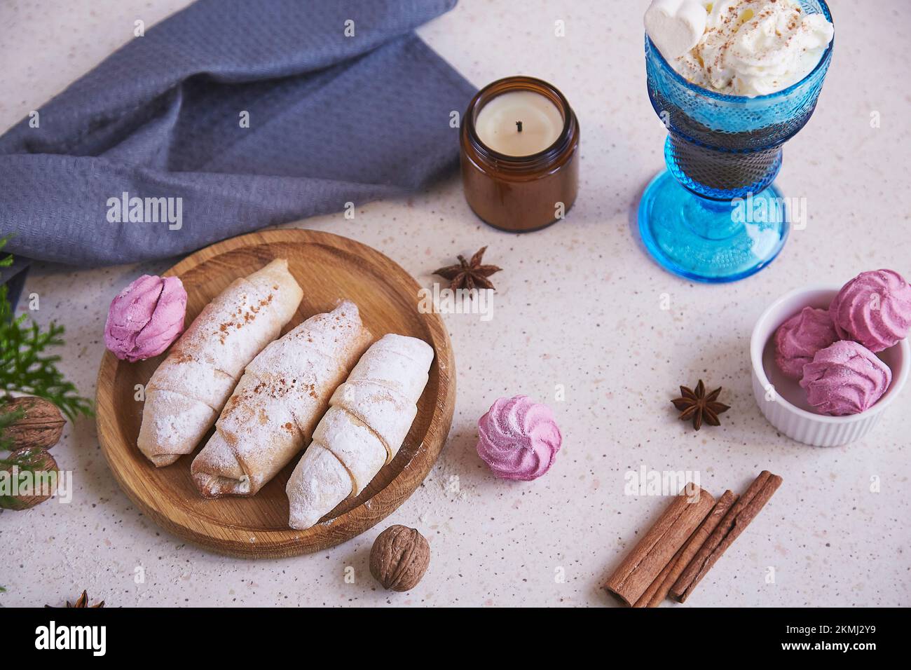 Aesthetic handmade Christmas crescent bagels and marshmallow,star anise, candle and Viennese coffee. Cozy home. Stock Photo