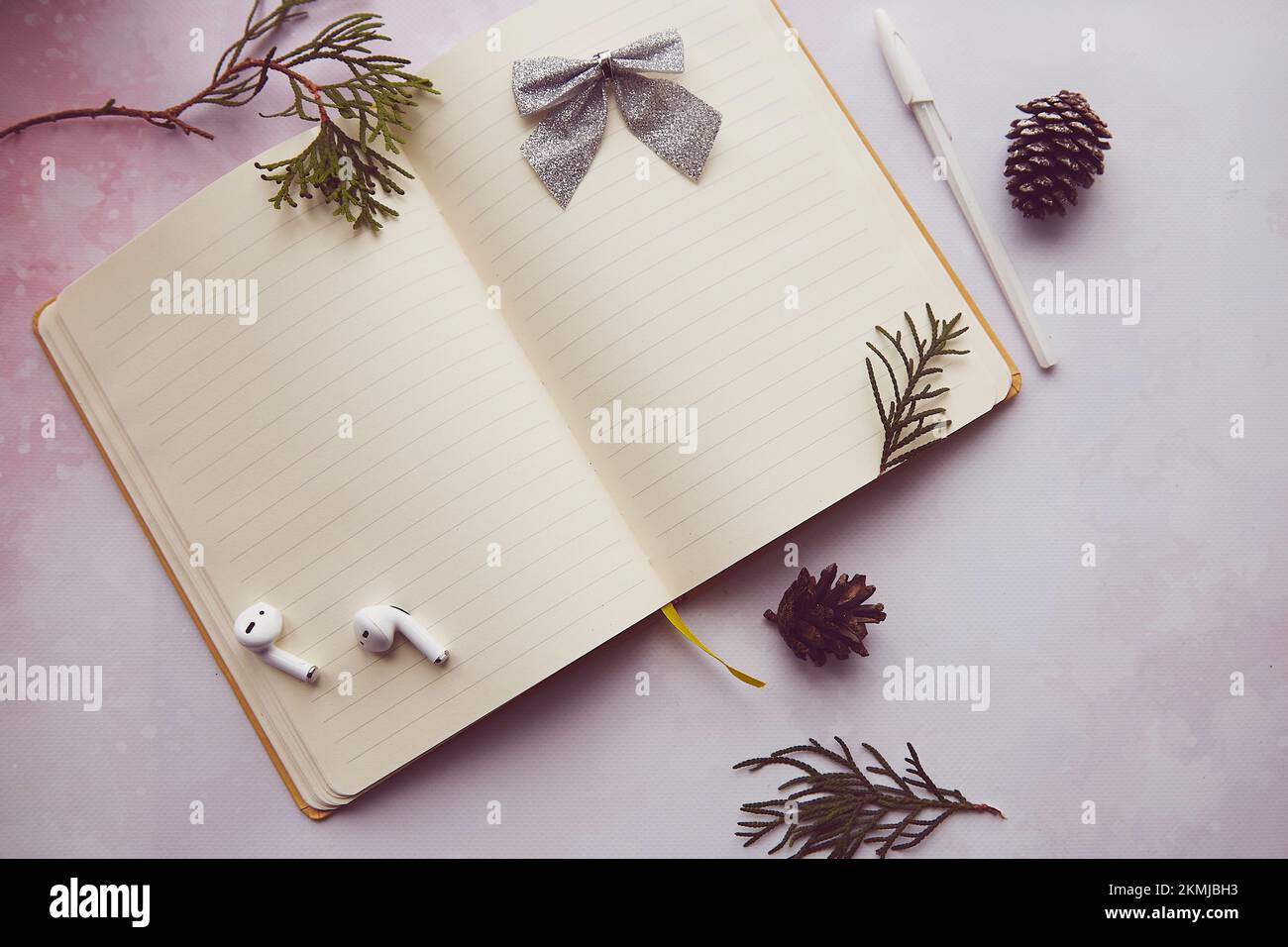 Seasonal vintage notepad mock up with winter decorations, earphones. New year resolution, new start and list of goals lifestyle. Stock Photo