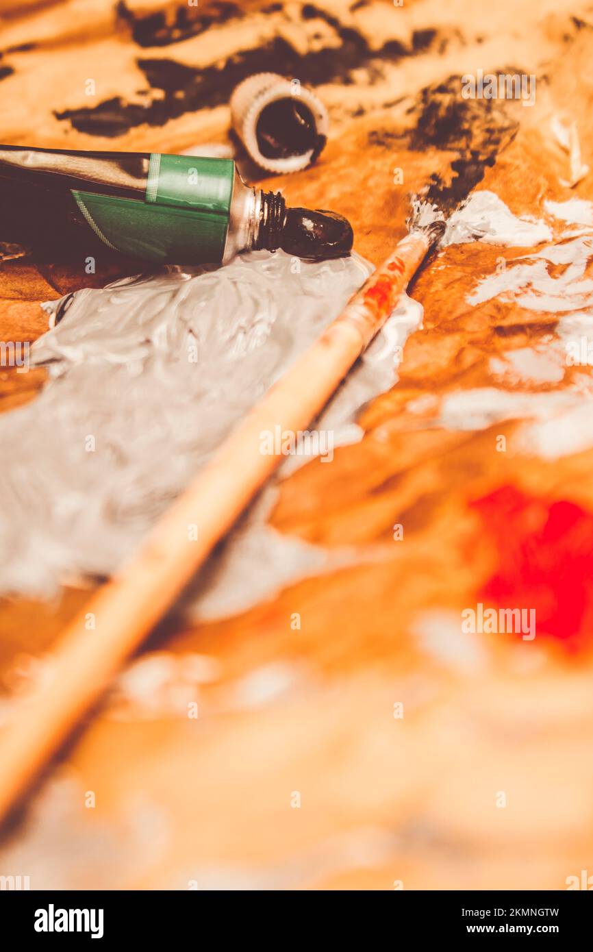 Low view on a mixing pallet of oil colours and brushes in tonal