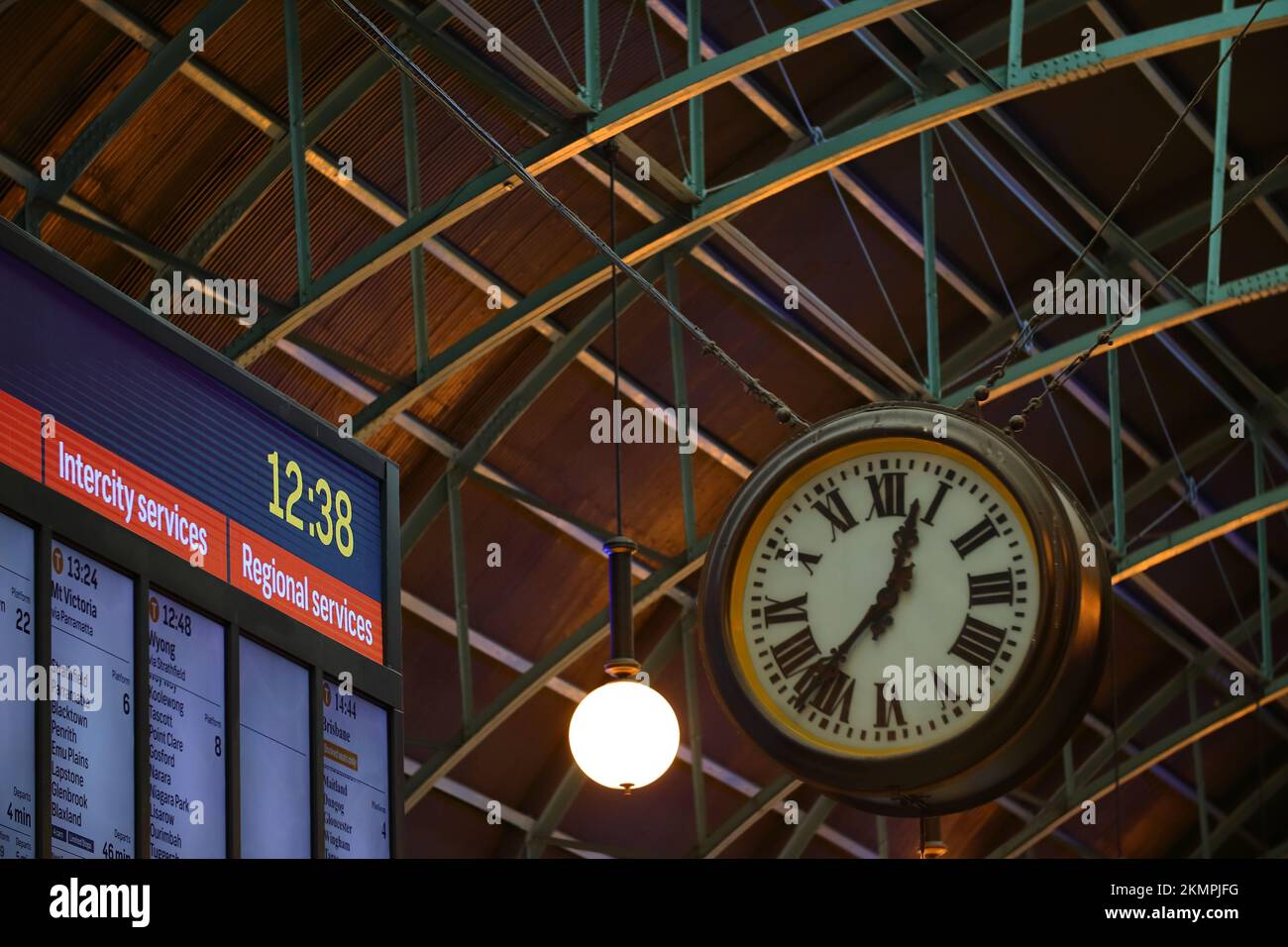 A vintage clock showing the time and the train timetable hang on the