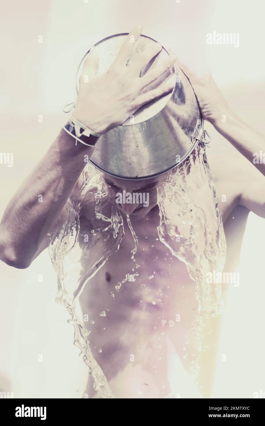 Creative purple toned portrait of a man pouring cold water from wine