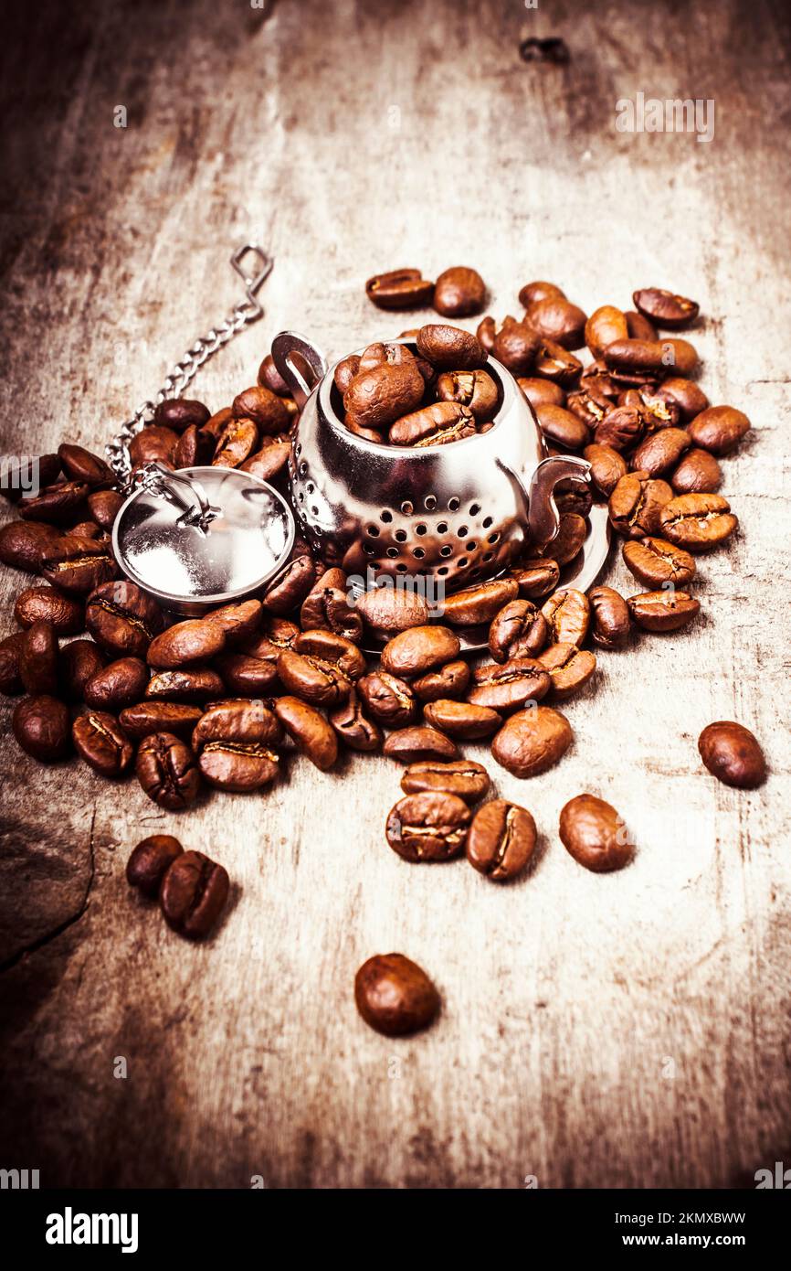 Quirky kitchenware still on a metallic tea pot overflowing with rustic