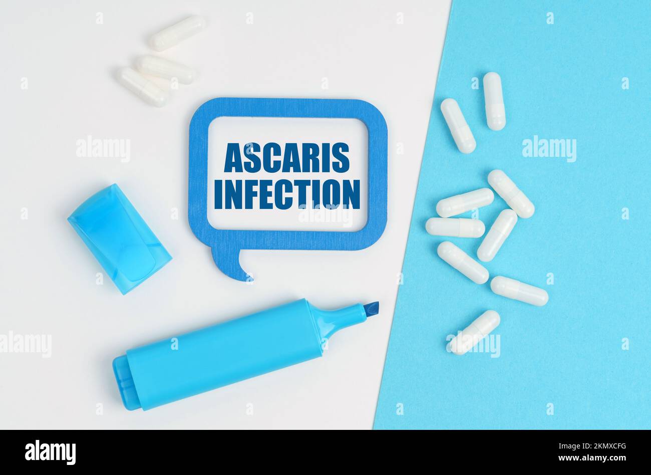 Medicine and health concept. On a white and blue table are pills, a marker and a blue plaque with the inscription - Ascaris Infection Stock Photo