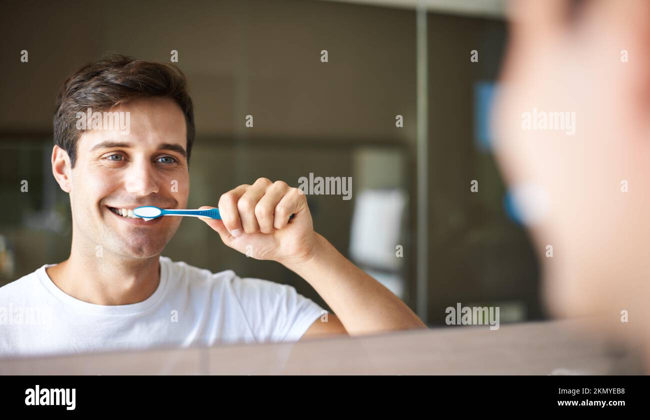 Keeping His Teeth Clean And Healthy Closeup Of A Young Man Brushing His Teeth In The Mirror 