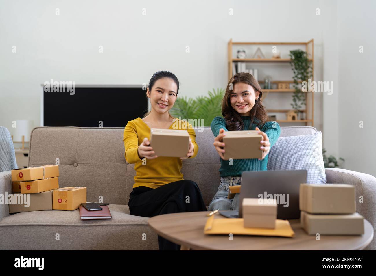 Young business woman working online e-commerce shopping at her shop. Young woman seller prepare parcel box of product for deliver to customer. Online Stock Photo