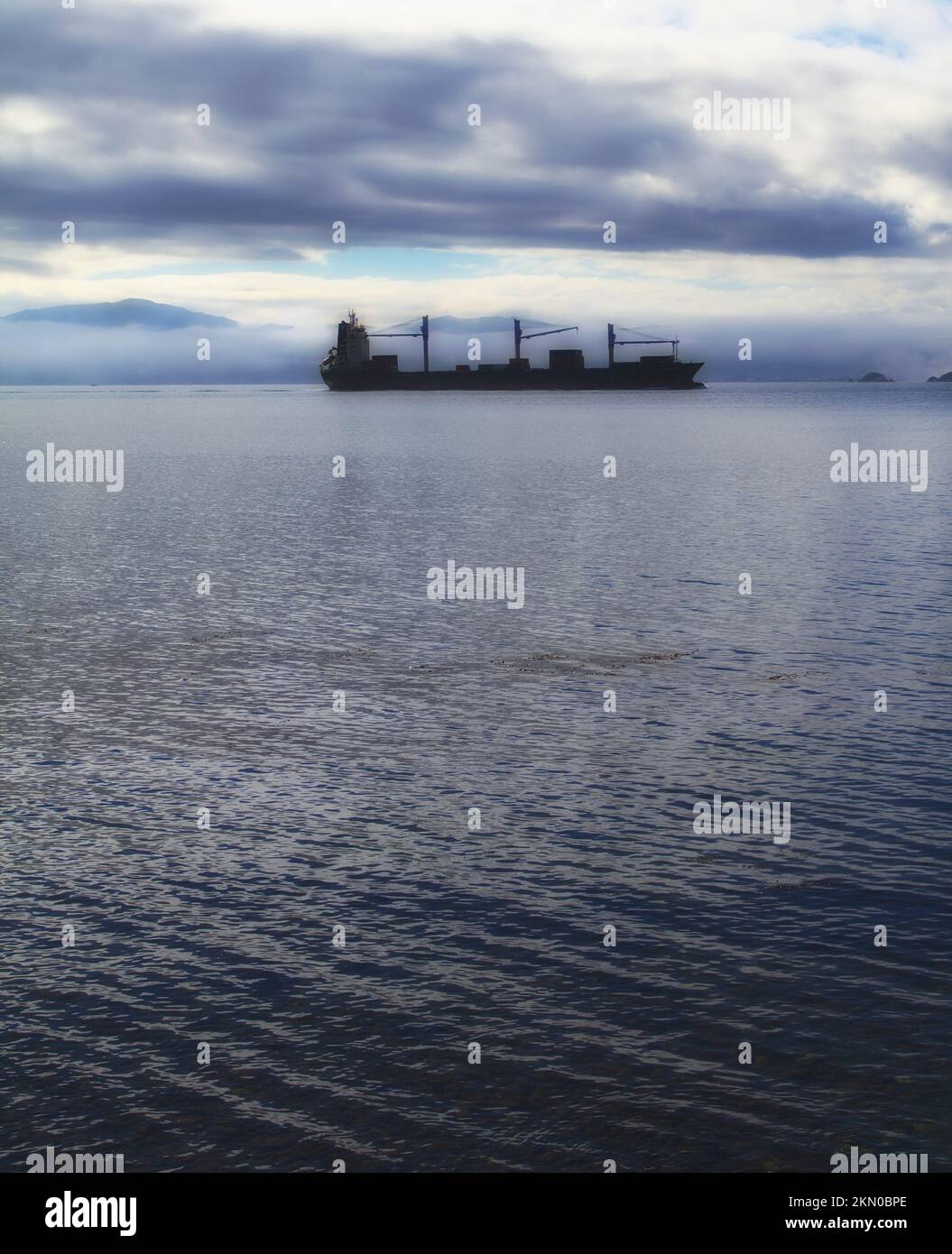 A photo of a cargo ship early morning Stock Photo - Alamy