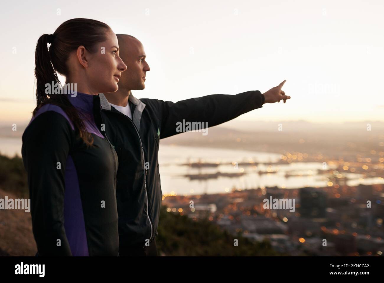 Dedicated to fitness and each other. a sporty young man pointing out the view to his girlfriend. Stock Photo