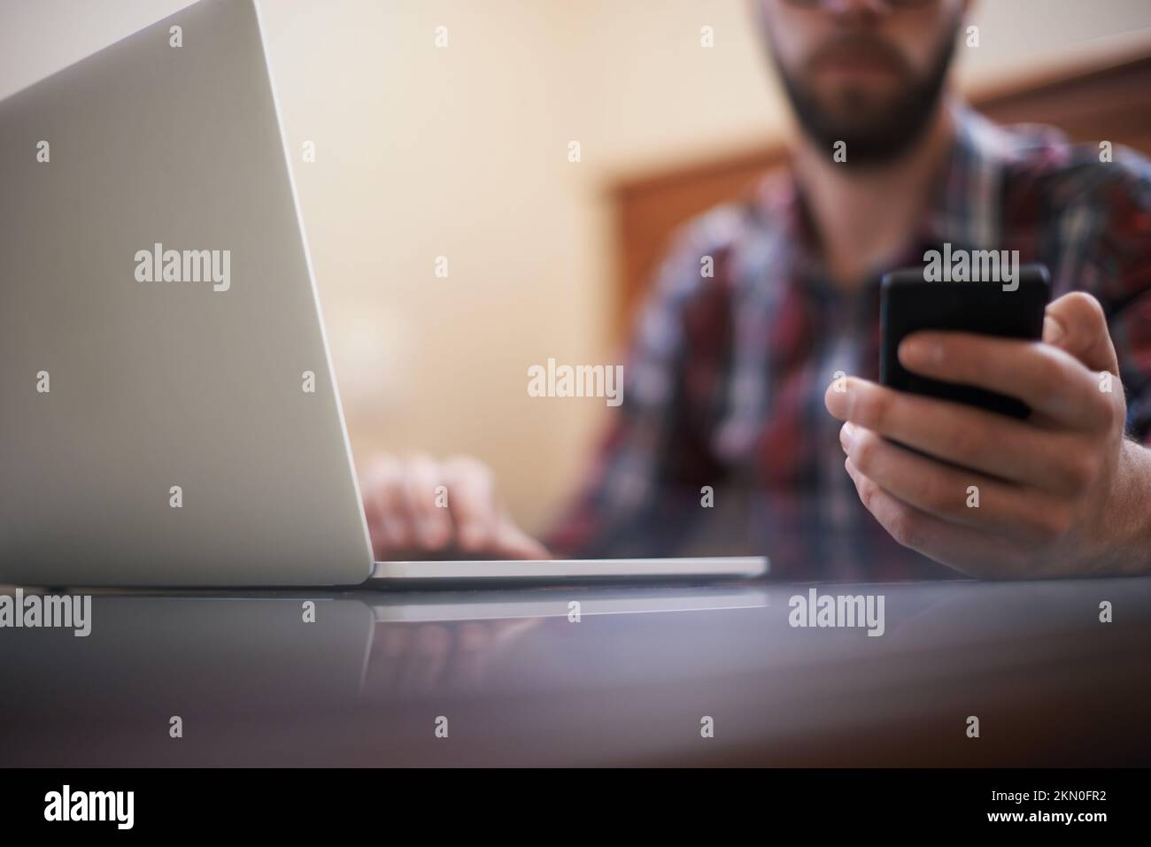 Hes connected in more ways than one. a man using a laptop and a cellphone. Stock Photo