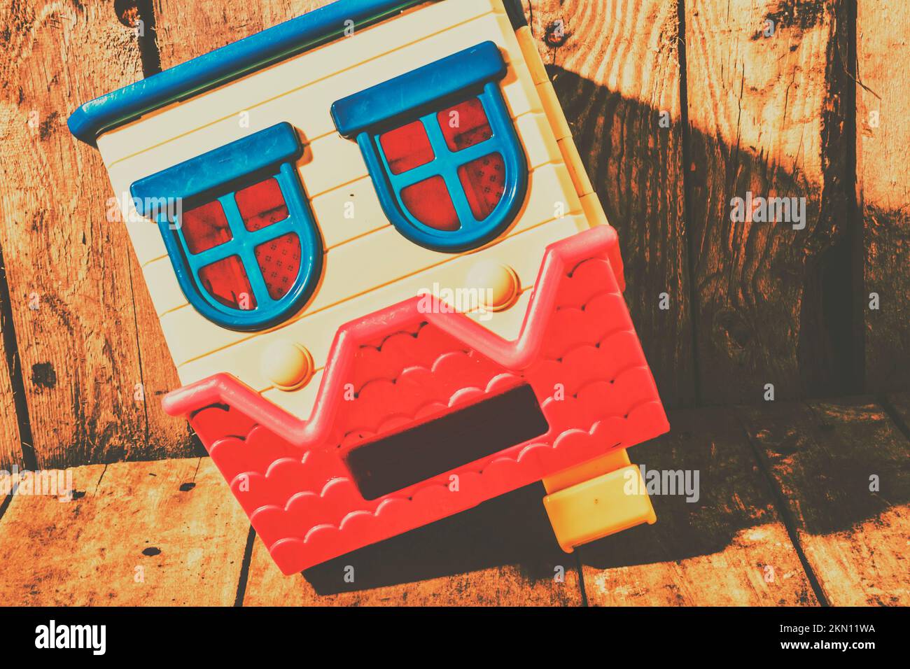 Dramatic still life scene of symbolic problems with tipped toy house