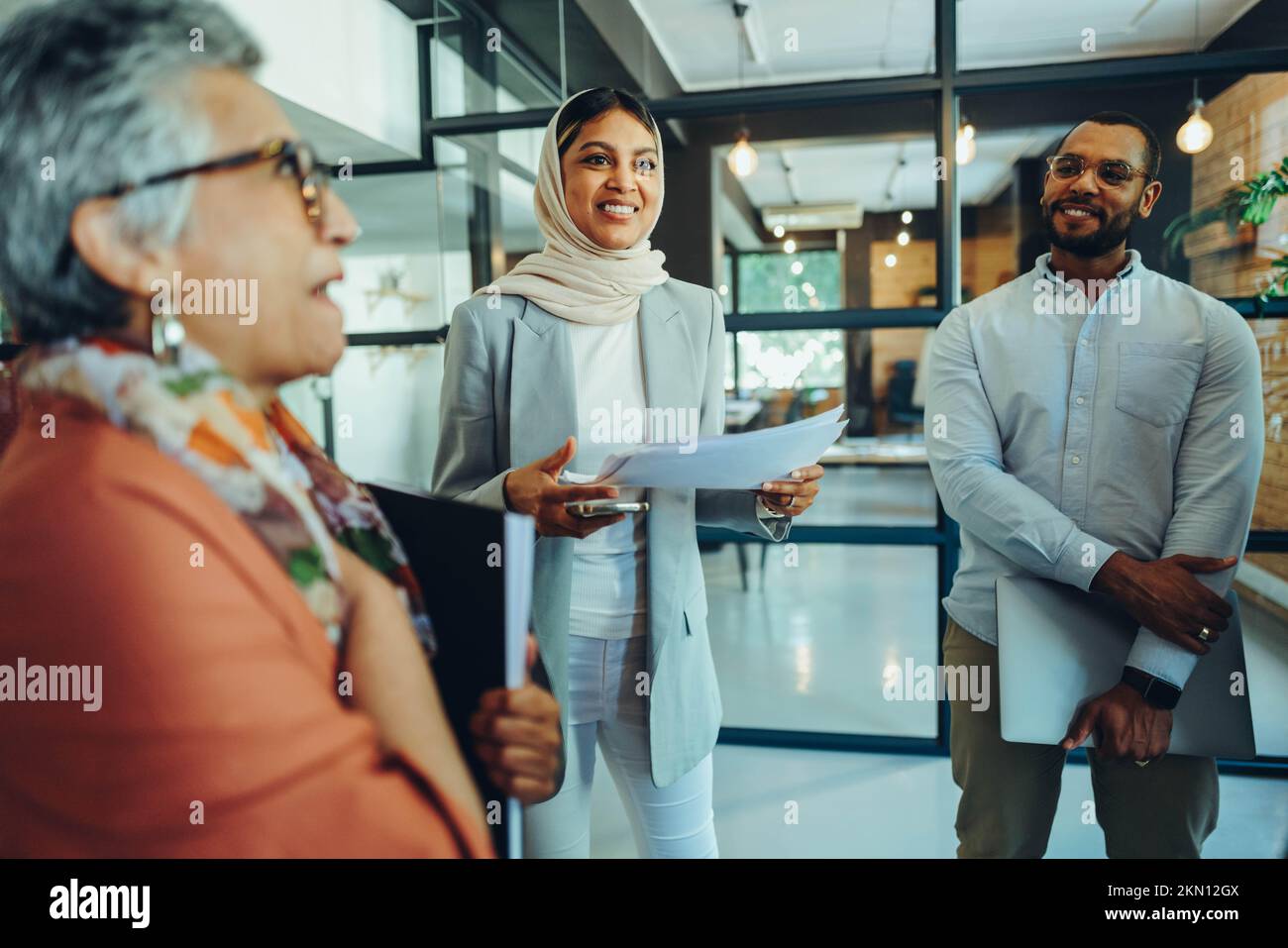 Multicultural businesspeople holding a staff meeting in a modern office. Group of diverse entrepreneurs running a successful startup in an inclusive w Stock Photo