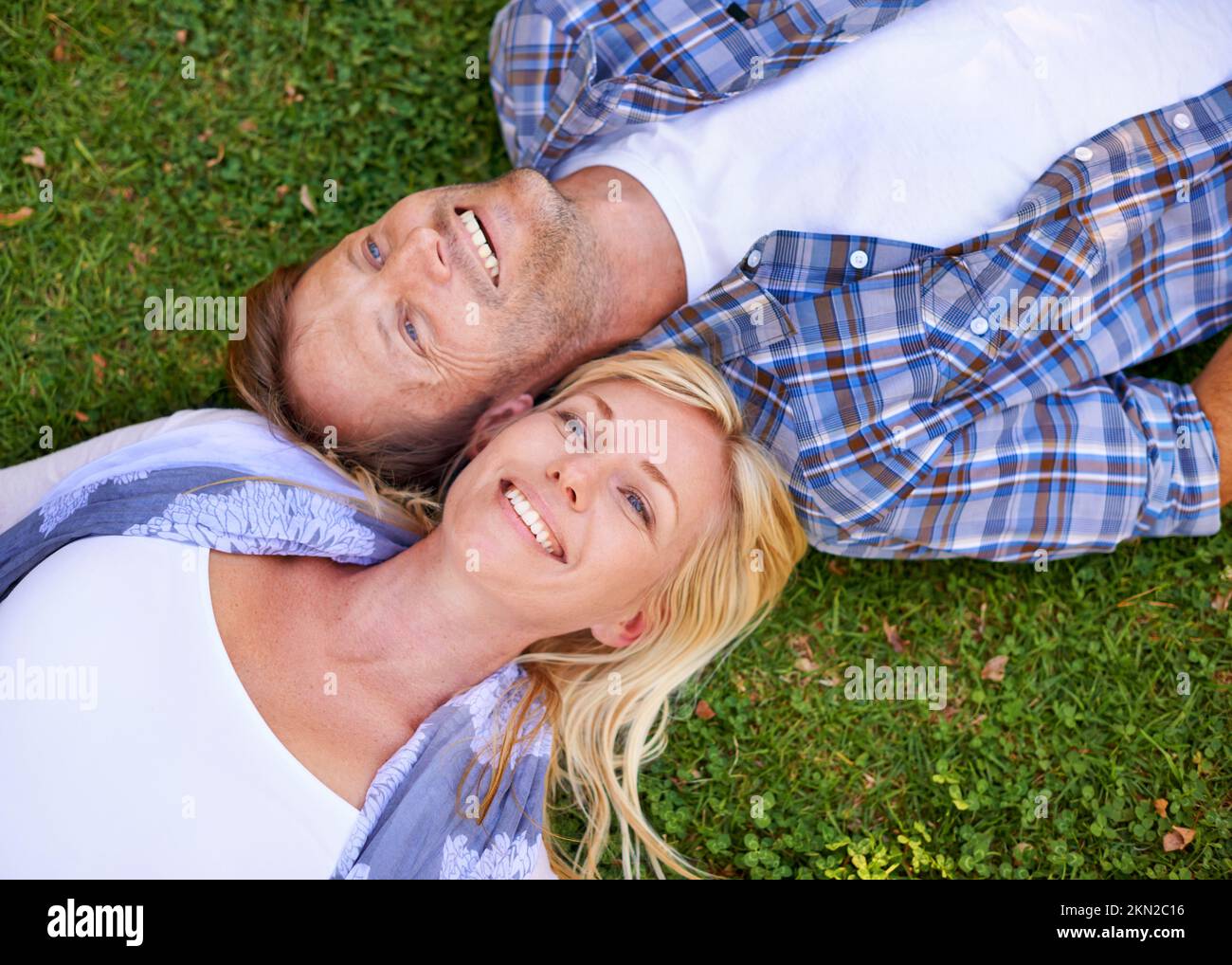 They lying in the park. High angle shot of an attractive couple lying ...