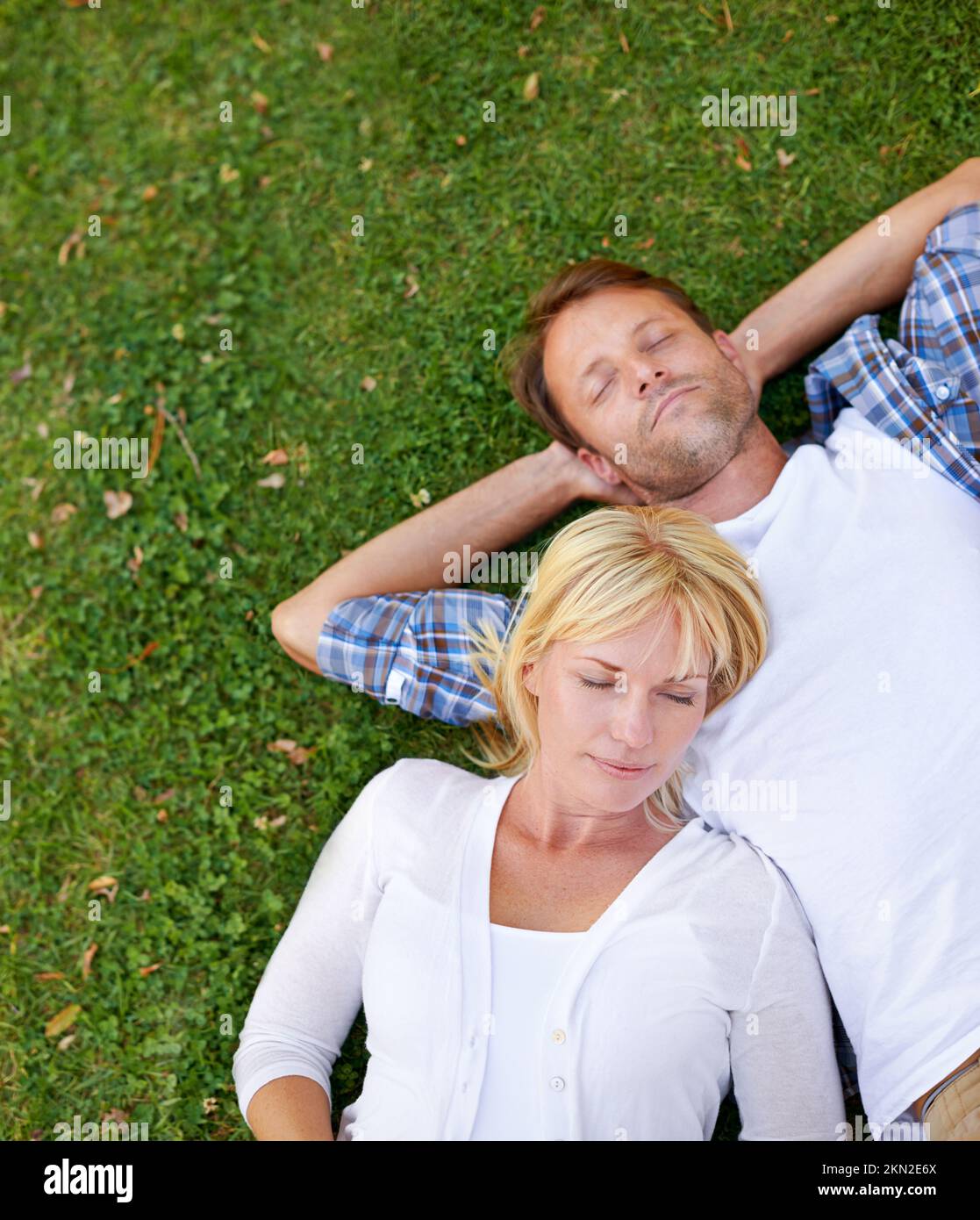 Relaxed in the park. High angle shot of an attractive couple lying ...