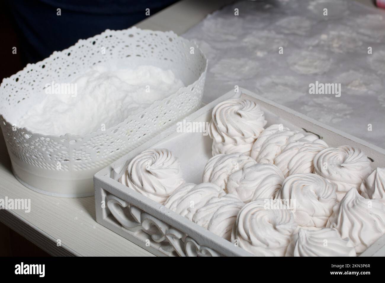 Homemade zephyr. White tray with marshmallows. Nearby is a container of