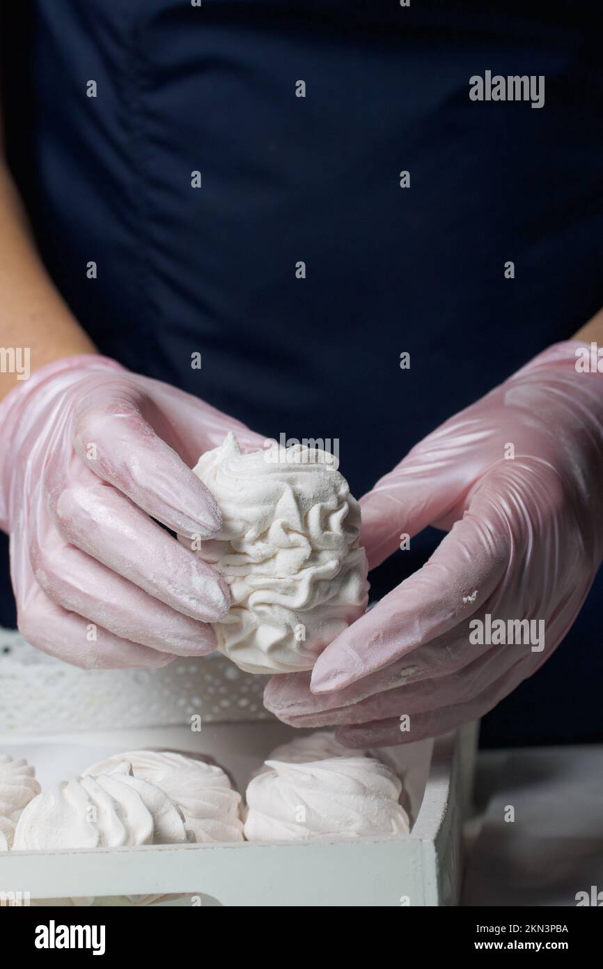 Homemade zephyr. Homemade marshmallows. A woman puts a readymade zephyr on a tray Stock Photo