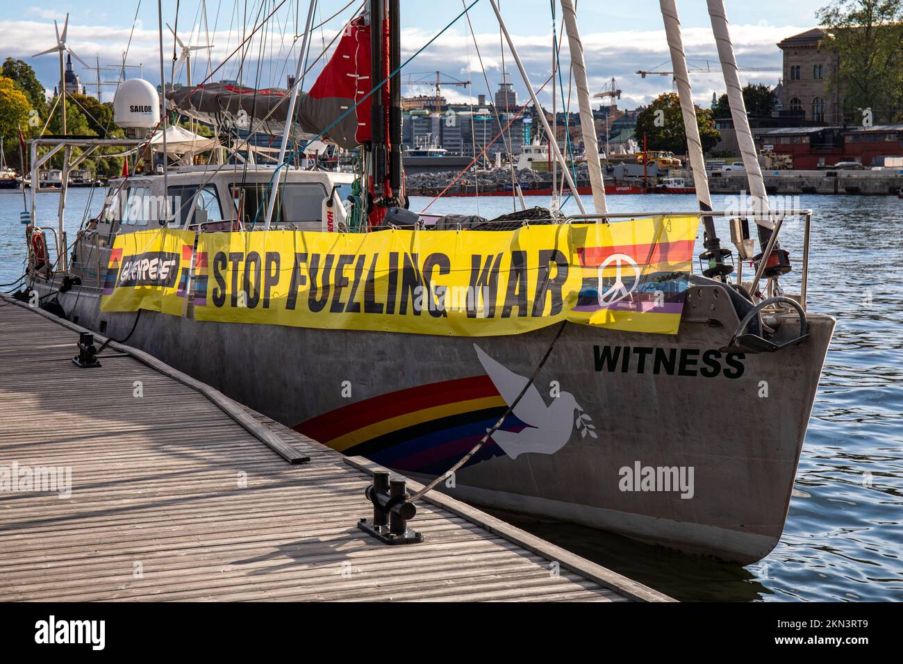 Stop Fuelling War banner on moored Greenpeace sailing vessel Witness in Stockholm, Sweden. Stock Photo