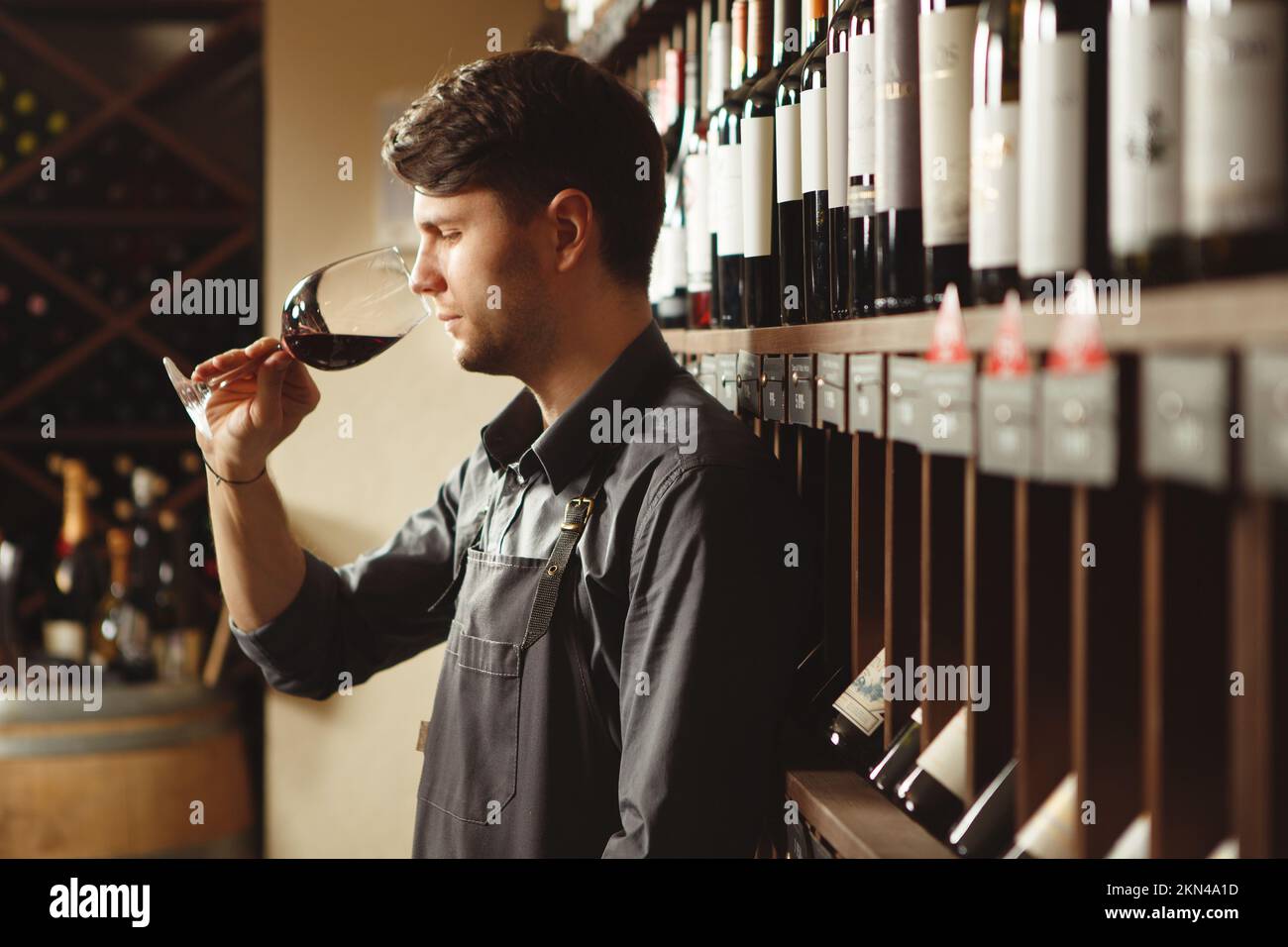 Bartender stands in cellar and smells wine in glass Stock Photo Alamy