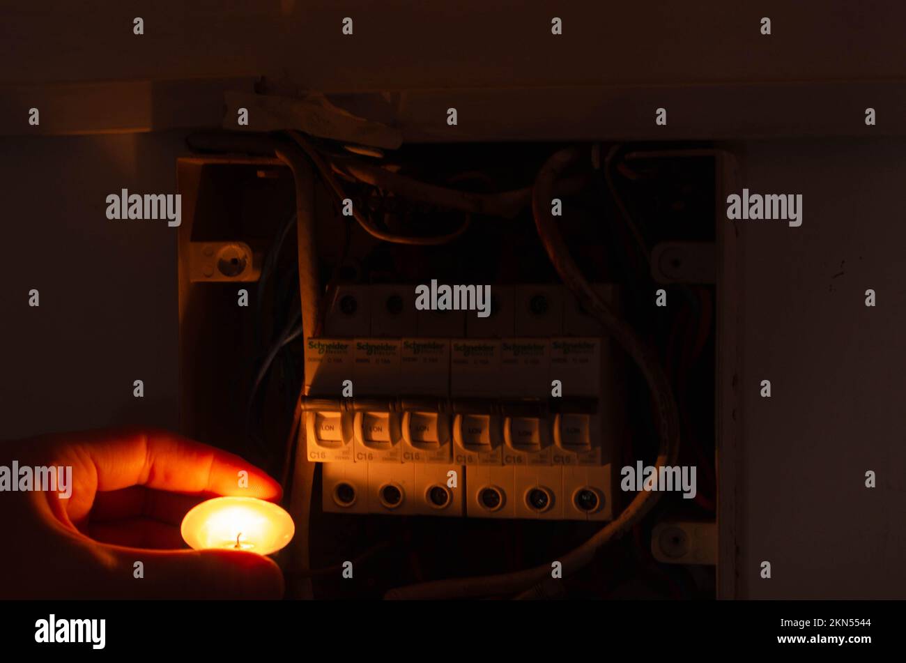 Blackout concept. Person's hand in complete darkness holding a holding a flashlight to