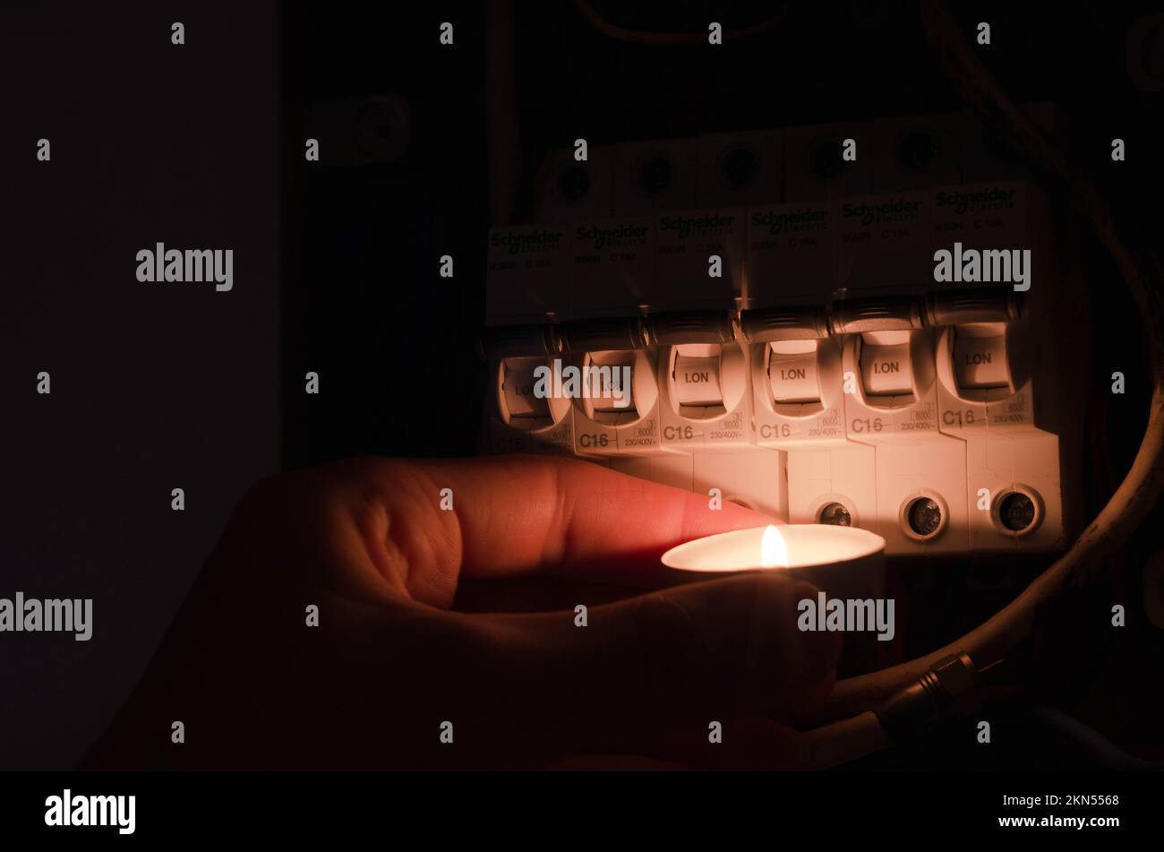 Blackout concept. Person's hand in complete darkness holding a holding a flashlight to