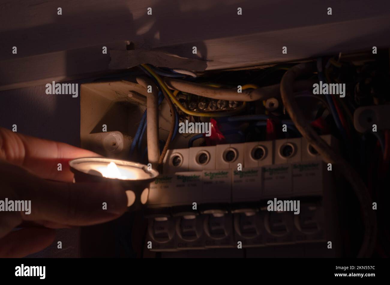 Blackout concept. Person's hand in complete darkness holding a holding a flashlight to