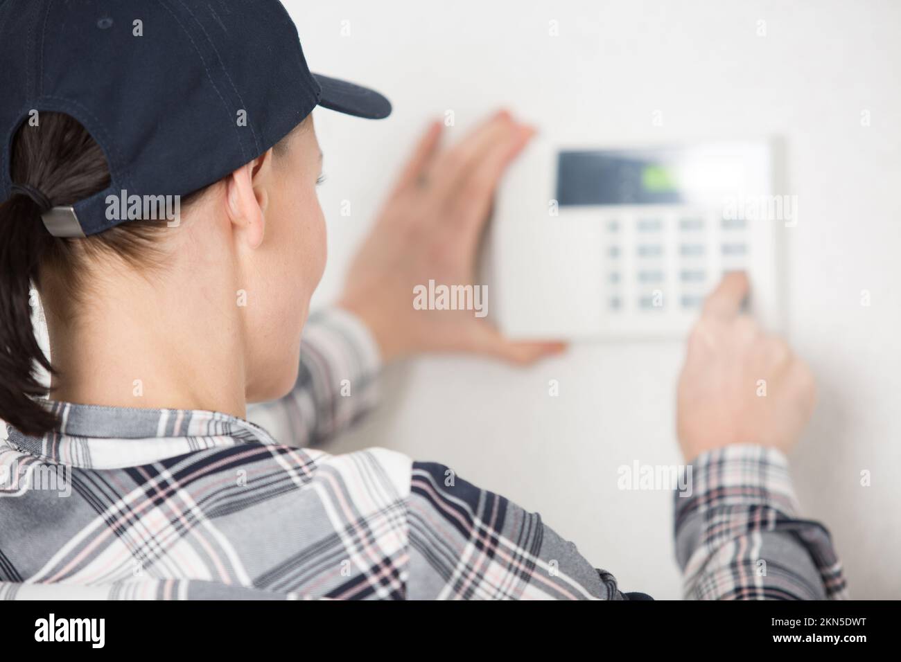 electrician woman installing a wall thermostat Stock Photo