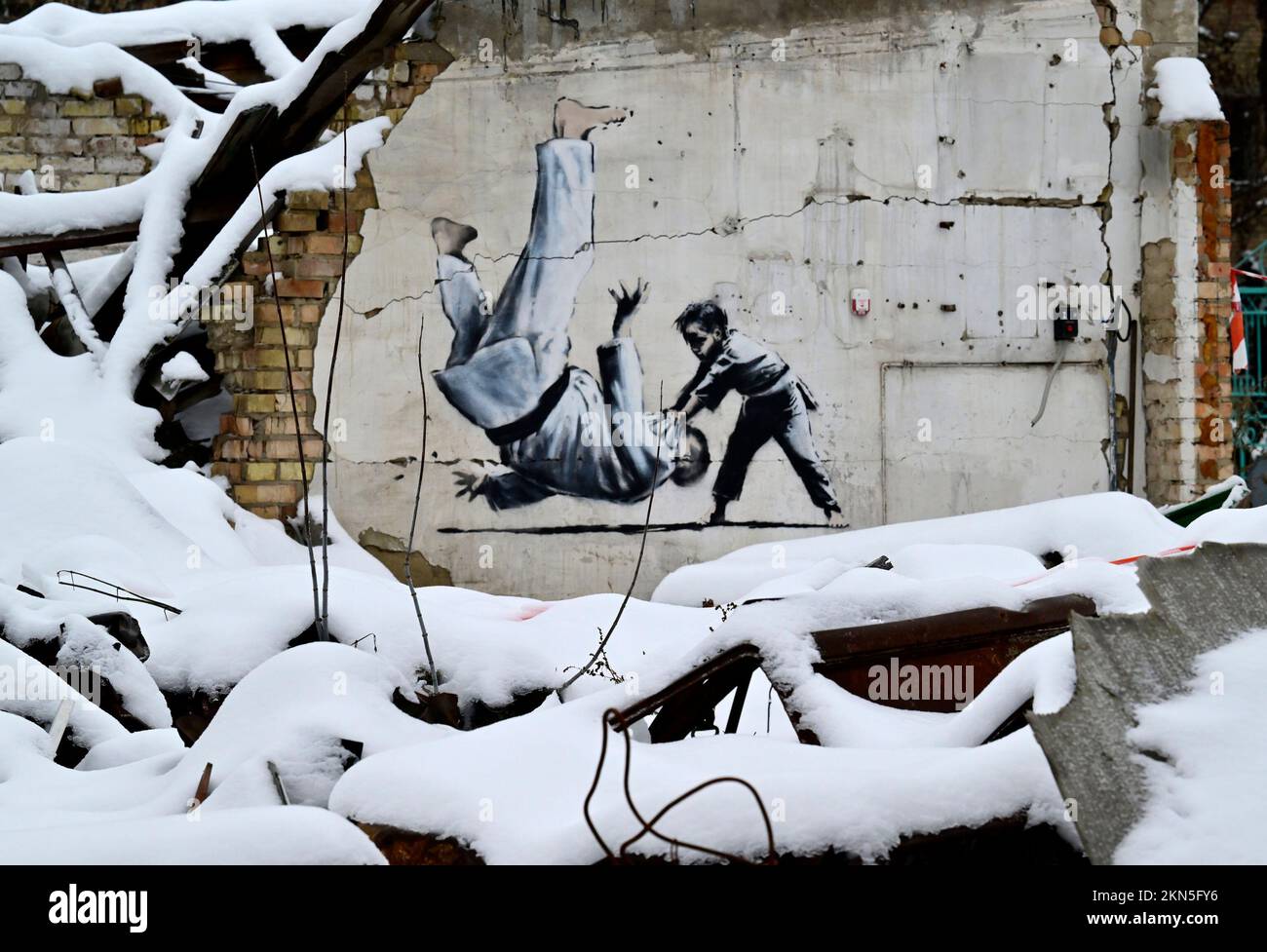 Illustration picture shows a Banksy graffiti showing a small boy throwing a grown up man in judo attire over his shoulder, painted on a piece of wall, during a visit to Borodianka in the Kyiv Oblast (province), on the second day of a visit to Ukraine, on Sunday 27 November 2022. Most of the buildings in Borodianka, a small town on an important access road to Kyiv, have been destroyed by Russian bombings in the first months of the Russian invasion. Prime Minister De Croo and Minister of Foreign Affairs Lahbib arrived in the Ukrainian capital Kyiv on Saturday for an unannounced visit. Nine month Stock Photo