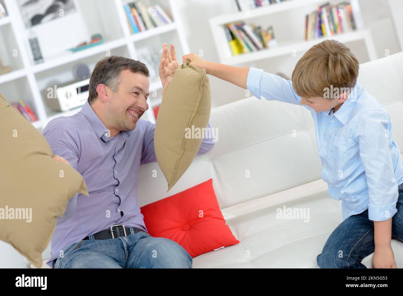 Adult and child having cushion fight Stock Photo Alamy