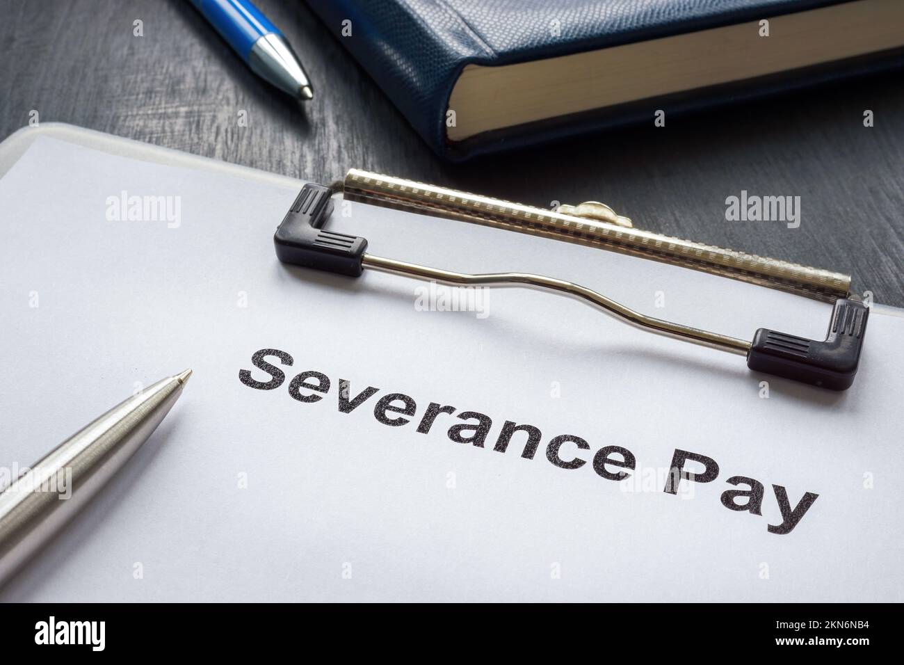 Clipboard with documents about severance pay and pen. Stock Photo