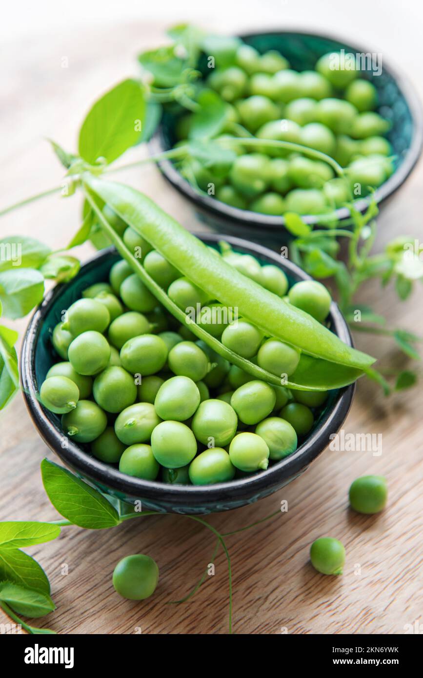 Bowl with young fresh juicy pods of green peas. Healthy organic food