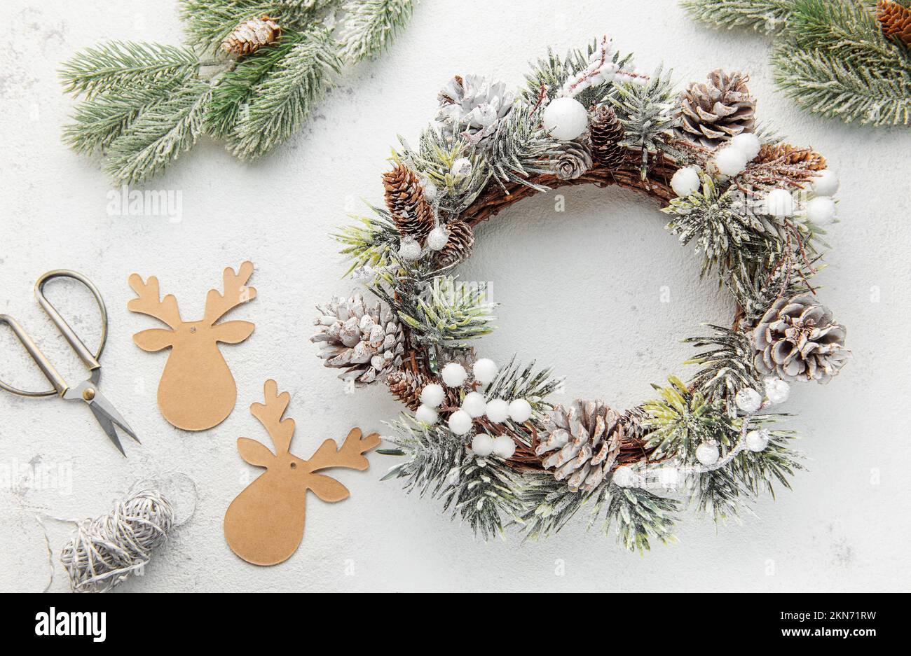 Decorative festive Christmas wreath. Wreath made of fir tree and cones on a grey concrete background. Christmas decorations Stock Photo