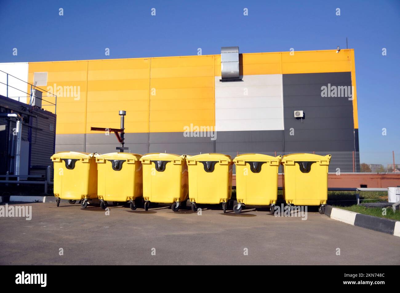 Yellow trash cans on wheels for organized waste collection Stock Photo