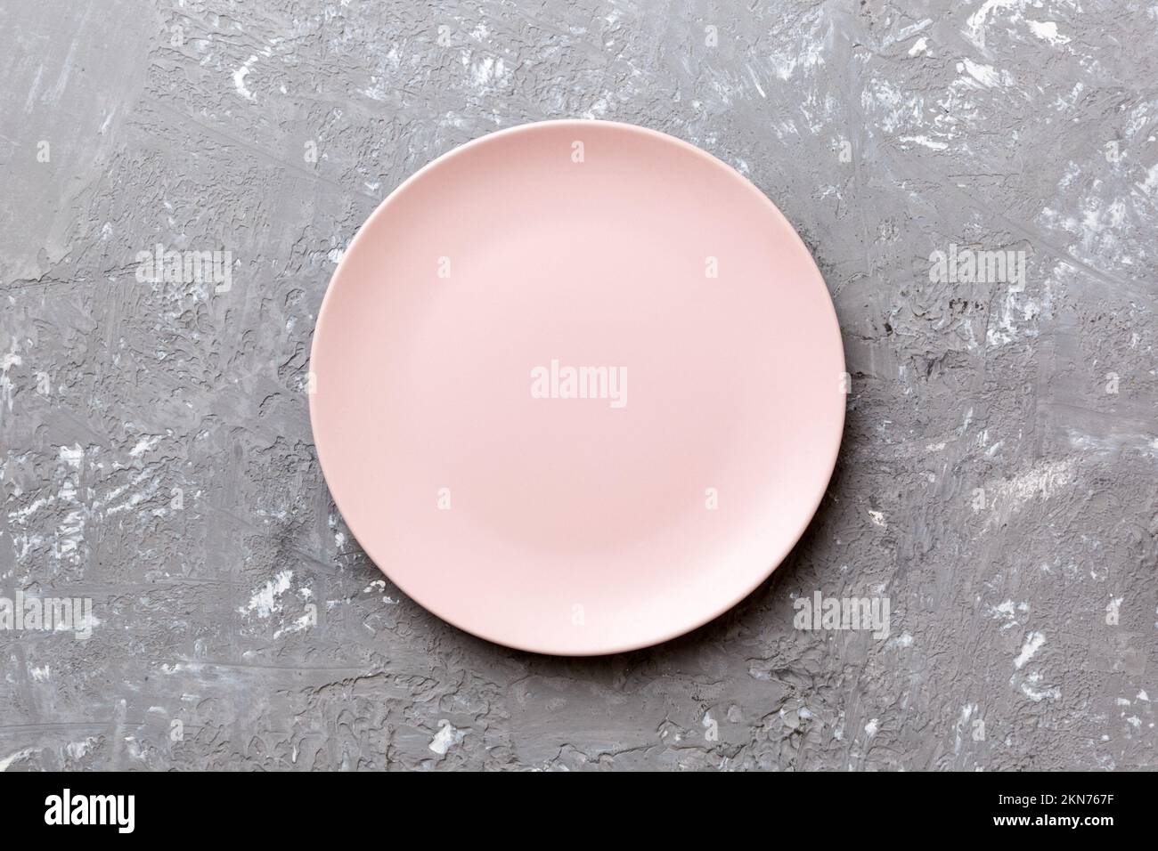 Top view of empty pink plate on cement background. Empty space for your ...