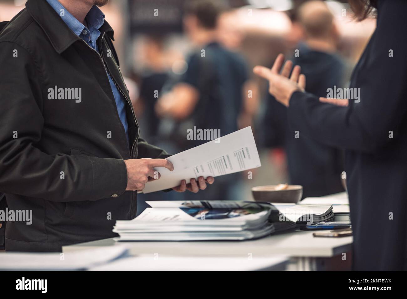 Business people exchanging business promotional materials and brochure on business meeting on trade-show. Business discussion talking deal concept Stock Photo
