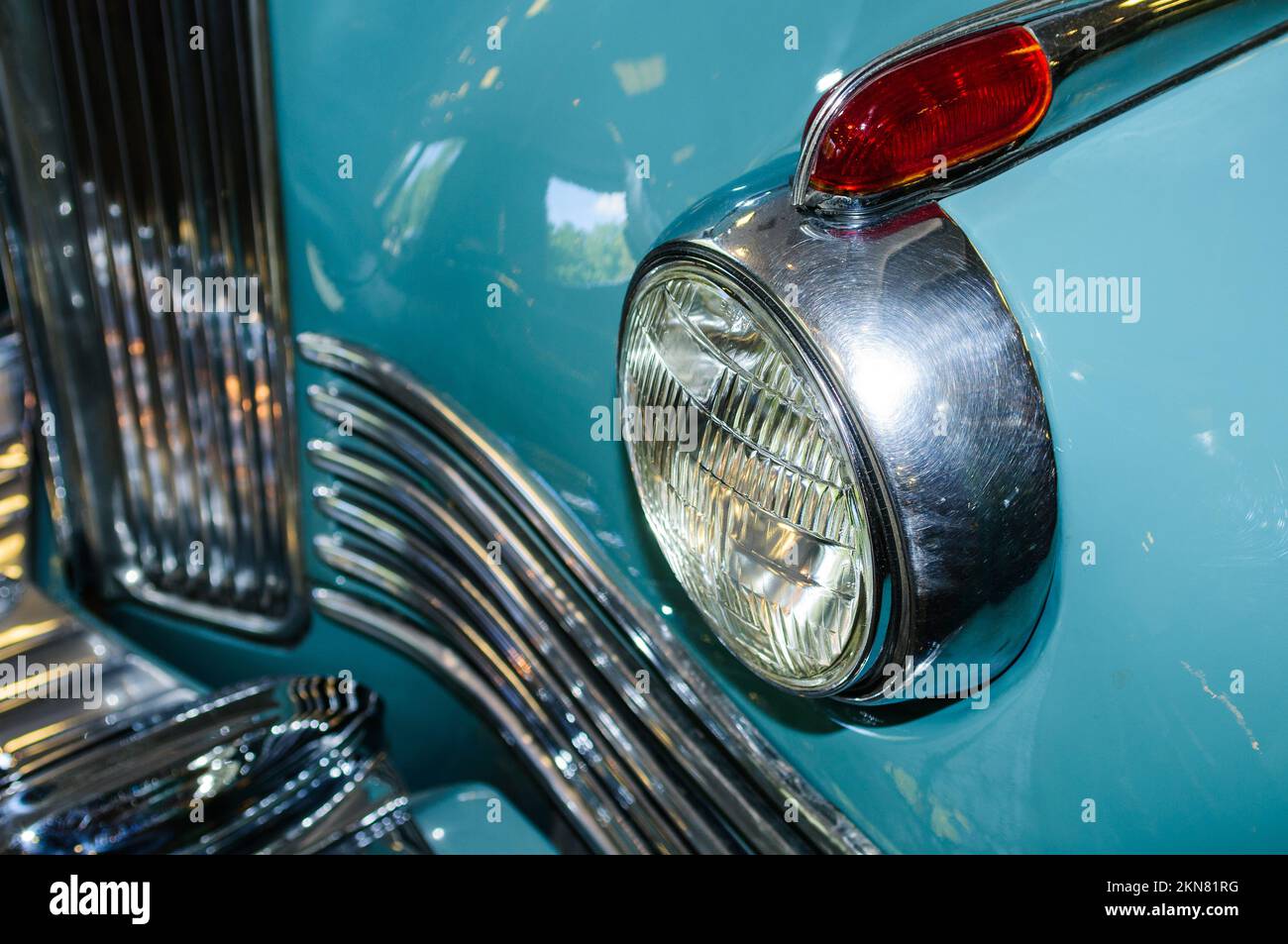 Detail of the front headlight of an old car in garage Stock Photo