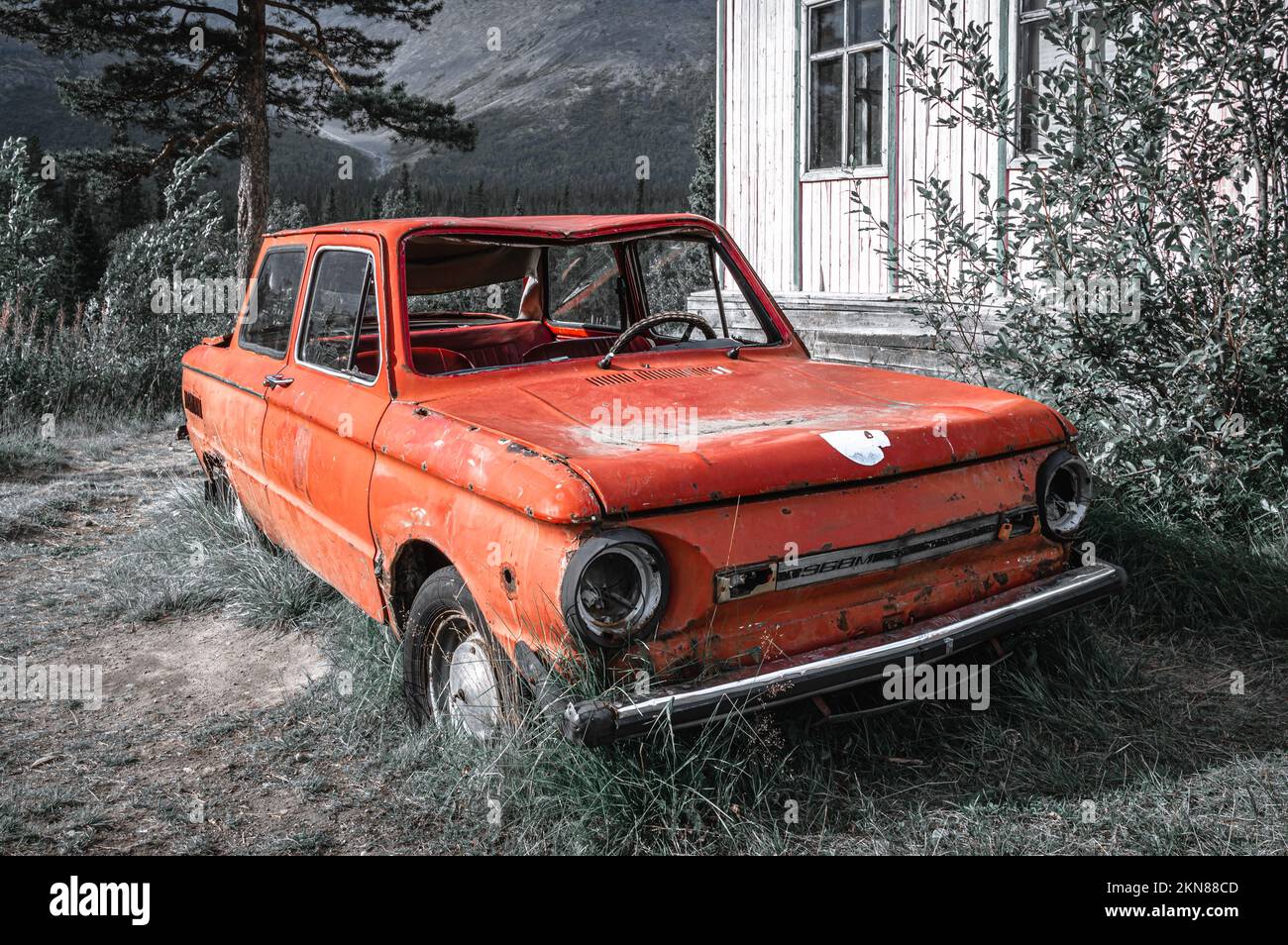 Picturesque view of an old soviet car against Khibiny forest. Kola Peninsula, Russia. Stock Photo