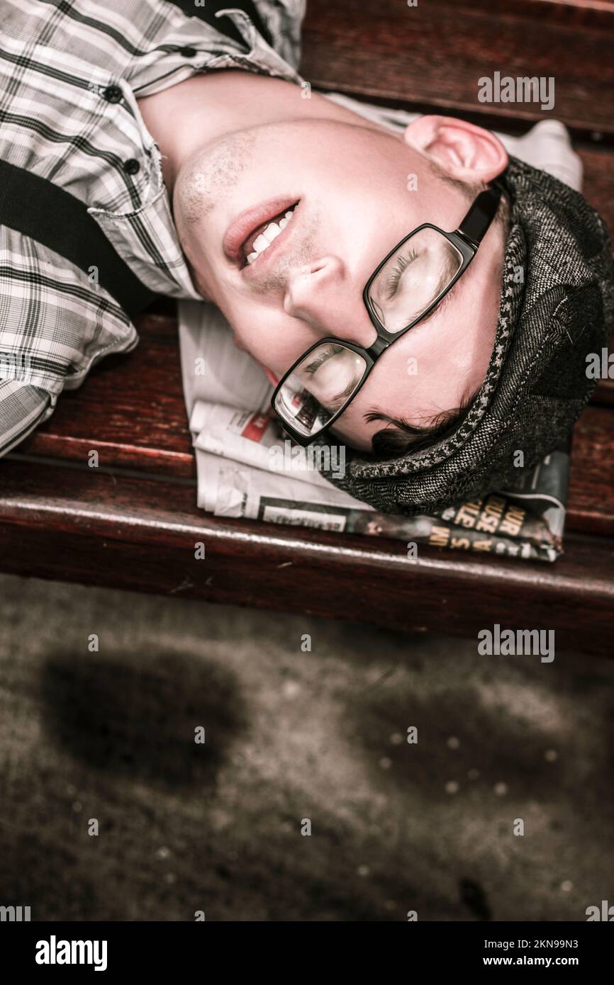 Old stylised portrait on the face of a man snoring of a folded up newspaper. Press at sleep Stock Photo