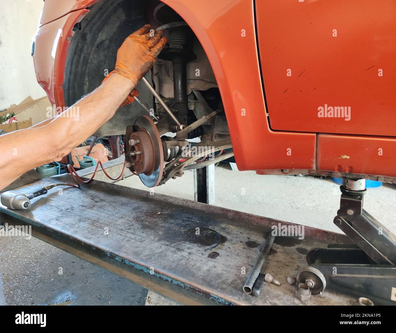 A mechanic replacing car disc brakes in the garage Stock Photo - Alamy