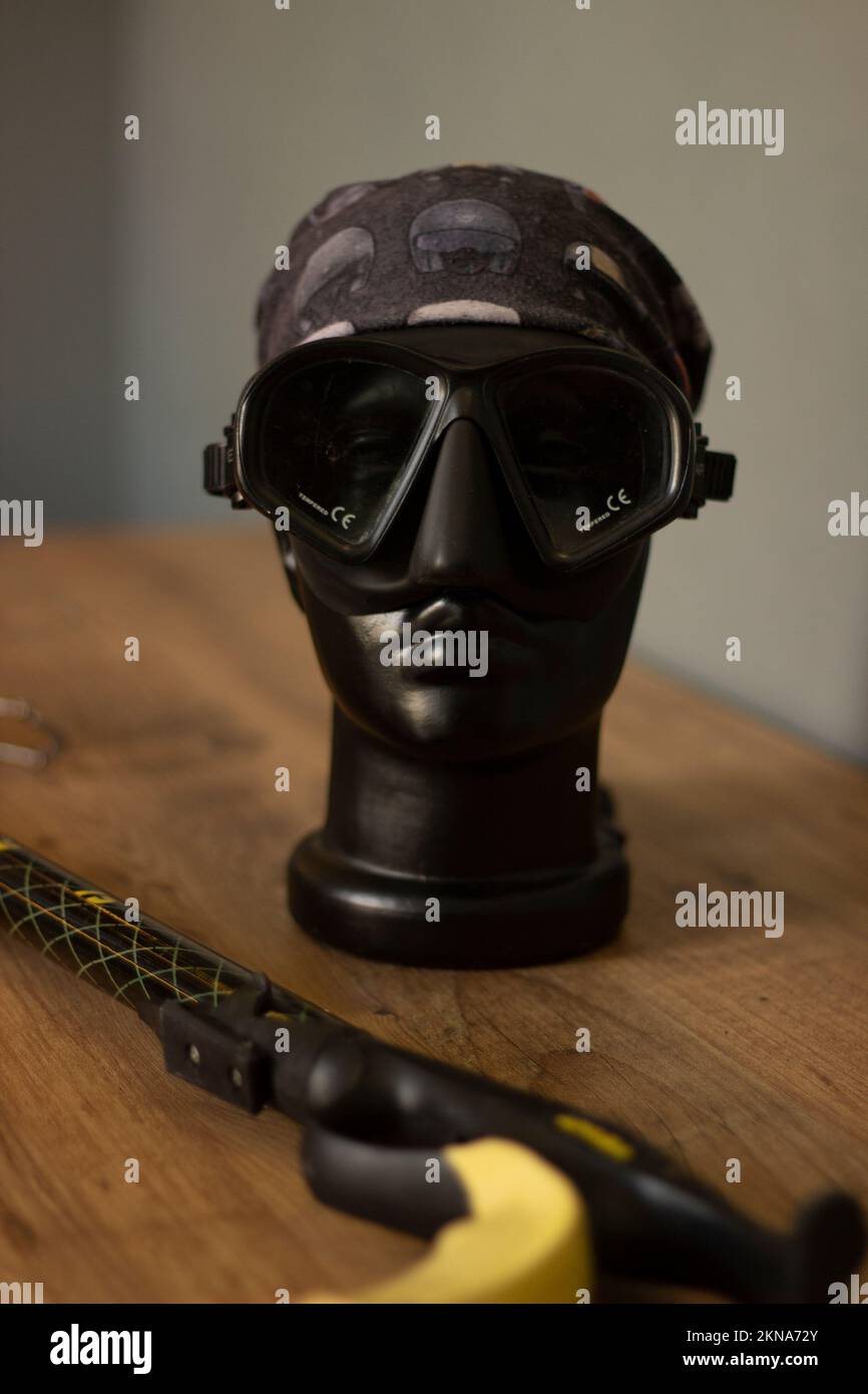 A vertical shot of a spearfishing tool and a diving mask on a
