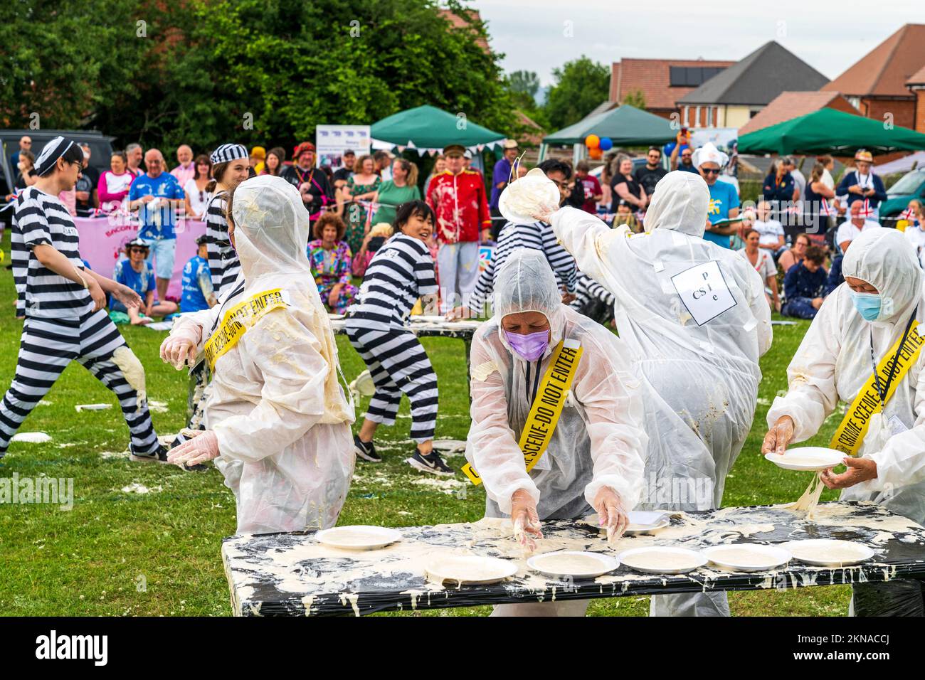Two teams of four people throwing custard pies at each other at the