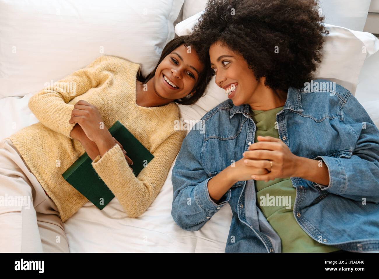 Girl lying on bed with book hi-res stock photography and images - Alamy