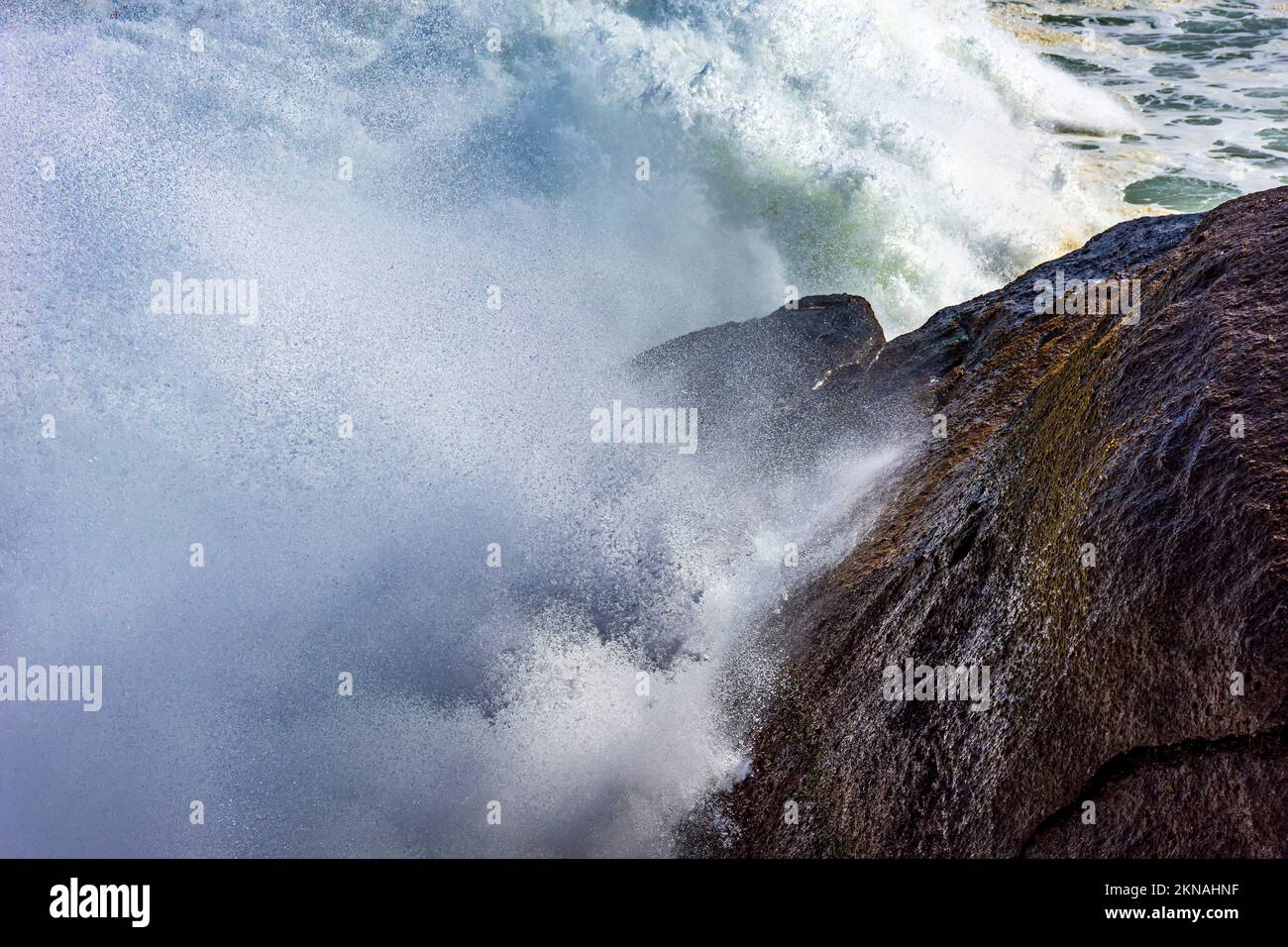 Big wave crashing against the rocks with sea water splashing in the air ...