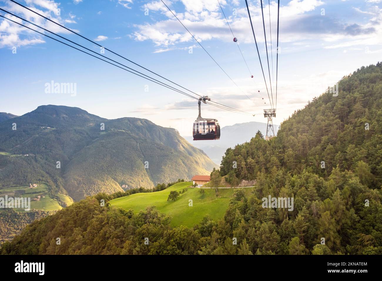 Cable car above valley at sunset. Bolzen, Italy Stock Photo