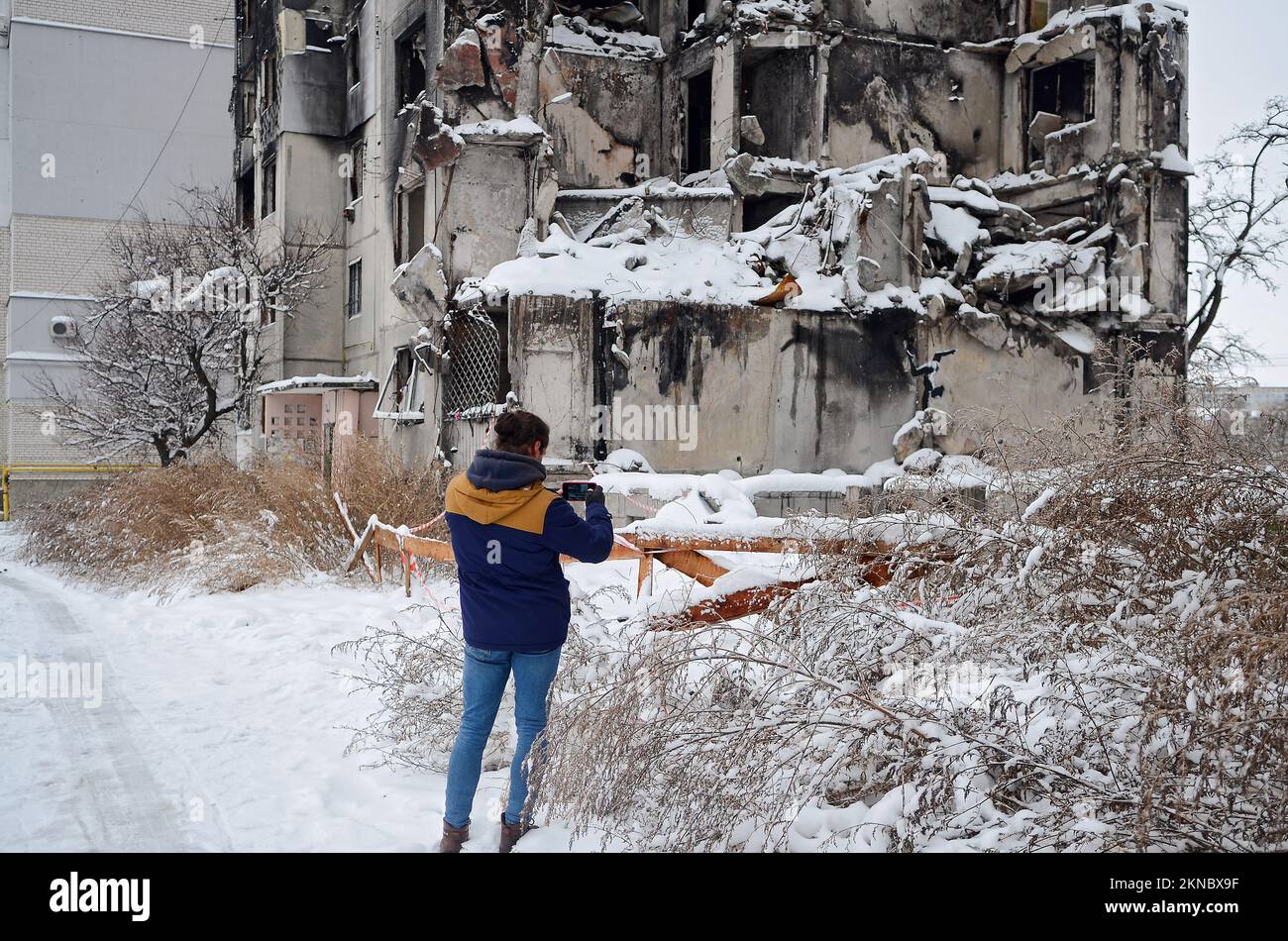 BORODIANKA, UKRAINE - NOVEMBER 22, 2022 - A woman takes a picture of the mural by England-based street artist Banksy that features a gymnast on the wa Stock Photo