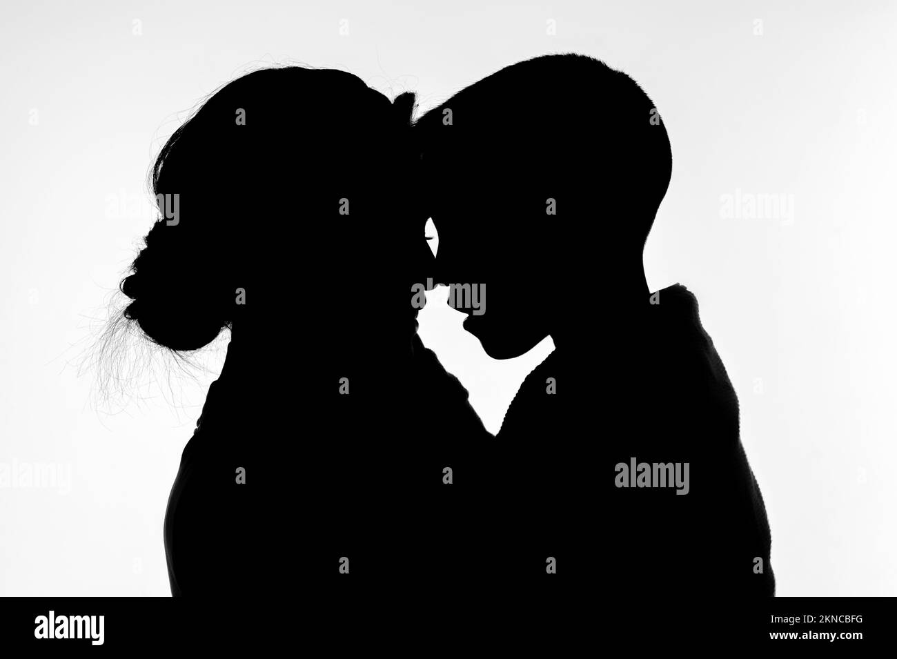 Silhouette of mother with son in her arms on a white background Stock Photo