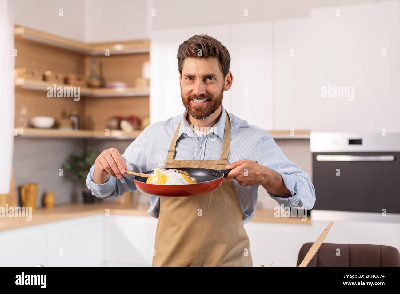 Man In Kitchen Happy attractive mature caucasian man with beard in apron prepare ...