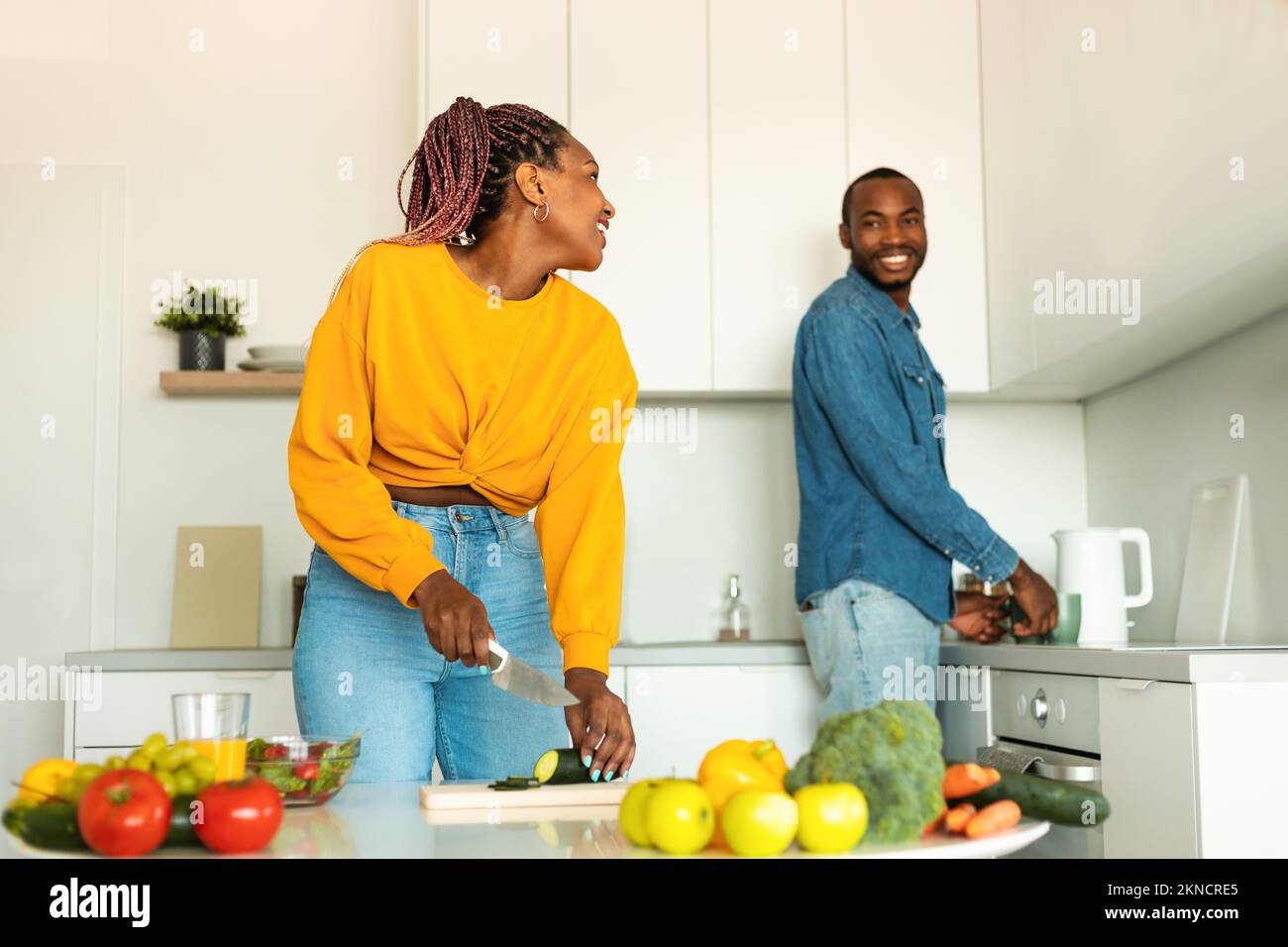 Happy african american couple preparing healthy food, spending time in ...