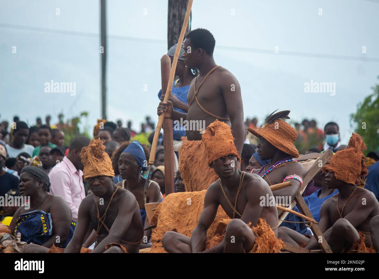 Men demonstrate how servants carried the litter containing their African king, wearing traditional animal skin clothing Stock Photo