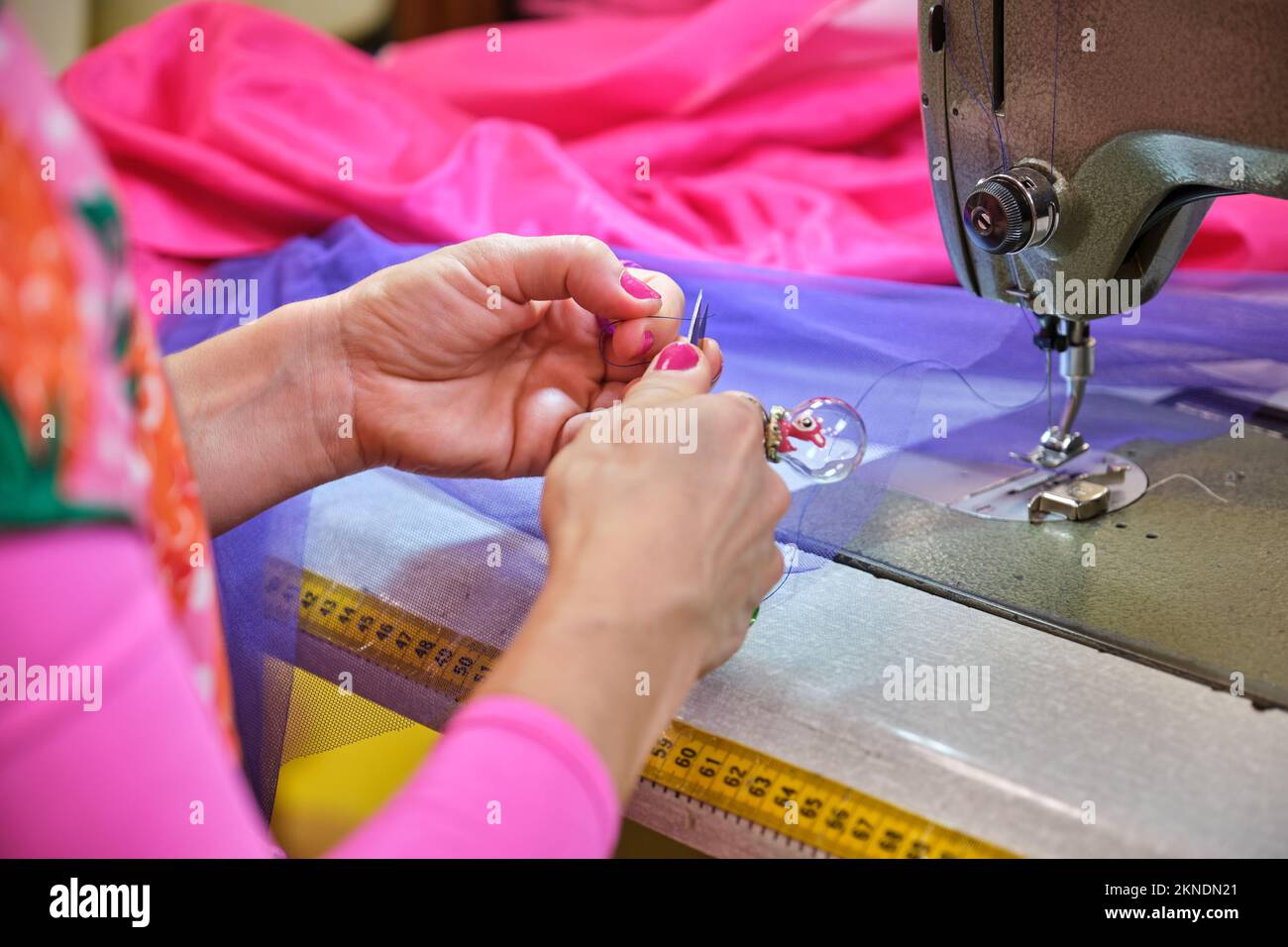 Unrecognizable dressmaker cutting the thread to threading sewing